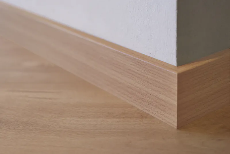 fussleiste-2fbdb489 Moderne Fußleiste in heller Holzoptik an einem Wandübergang mit Parkettboden.